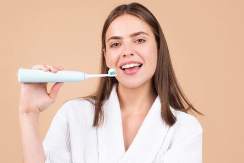 A women with an electric tooth brush