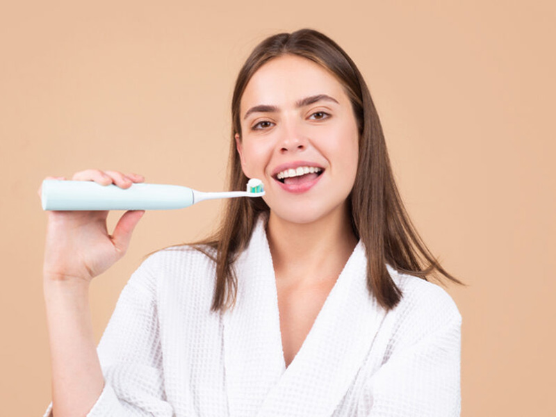 A women with an electric tooth brush